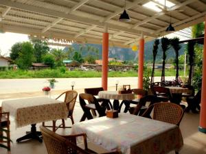 a restaurant with tables and chairs and a patio at Wild Orchid Villa Krabi in Ao Nam Mao