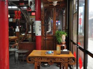 a wooden table in front of a building with a room at Pingyao Yufengheng Hotel in Pingyao