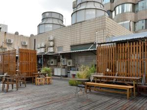 a patio with wooden benches and tables in front of a building at Shanghai Blue Mountain Bund Youth Hostel in Shanghai