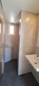 een badkamer met een wastafel en een toilet en een raam bij 103B nieuwe vakantie woning met sauna vanaf juli 2024 in Westkapelle