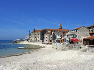 a group of buildings on a beach next to the water at Holiday Home Kastel in Kaštel +10 photos