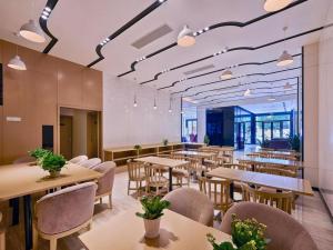 a restaurant with tables and chairs and a cafeteria at Lavande Hotel Tianjin Binhia Yujiabao Finance Center Branch in Binhai
