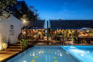 einen Pool vor einem Haus mit einem Restaurant in der Unterkunft Mira Residence & Resort (halal) in Chiang Mai