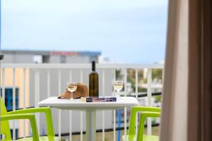 a table with a bottle of wine and two glasses at Manias Apartments in Kos