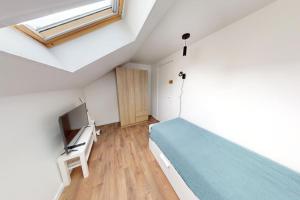 a bedroom with a bed and a television in it at Studio Coty 2èmeG in Le Havre