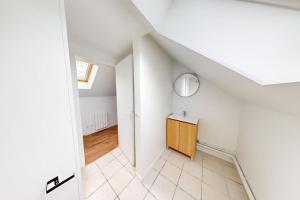 a white room with a wooden cabinet and a staircase at Studio Coty 2èmeG in Le Havre