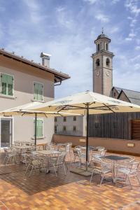 a group of tables and chairs with a clock tower at Albergo Tuenno in Tuenno