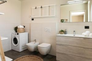 a bathroom with a toilet and a sink and a washing machine at Casa di Pina - Iris - Dalia in Monforte dʼAlba +27 photos