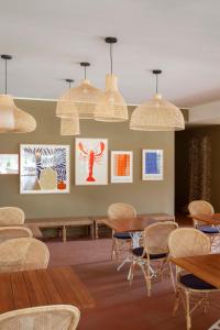 a room with tables and chairs and pictures on the wall at Is Molas Resort in Pula