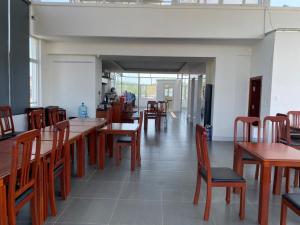 Un comedor con mesas y sillas de madera. en SinE Hotel VT by BAY LUXURY, en Vung Tau