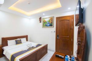 Un dormitorio con una cama y un televisor de pantalla plana. en SinE Hotel VT by BAY LUXURY, en Vung Tau