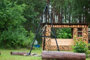 a log cabin with a swing in the grass at Przystań Osiek in Osiek