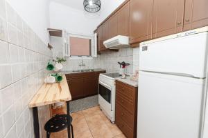 a small kitchen with a white refrigerator and a table at Chrysa's apartment in Anemómylos