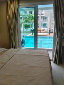 ein Schlafzimmer mit einem Bett und Blick auf einen Swimmingpool in der Unterkunft A studios精致的漂亮的房间可做饭 in Nong Prue