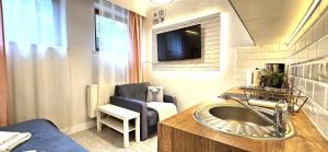 bagno con lavandino e TV a parete di Bystra Woda Studio Zakopane a Zakopane Altre 16 foto