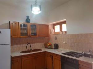 a kitchen with wooden cabinets and a sink and a stove at Apartman J&F in Smokvica +9 photos
