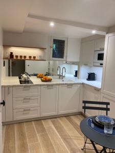 a kitchen with white cabinets and a table at Appartement privé avec jardin in Boulogne-Billancourt