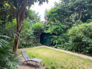 a bench sitting in the grass in a garden at Appartement privé avec jardin in Boulogne-Billancourt
