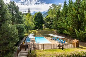 an overhead view of a swimming pool with chairs and trees at Résidence Pierre & Vacances Les Trois Domaines in Ax-les-Thermes