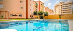 a large swimming pool in a city with buildings at Apartamento Veramar en Fuengirola in Fuengirola
