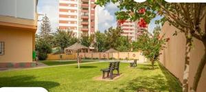 two benches in a park with buildings in the background at Apartamento Veramar en Fuengirola in Fuengirola
