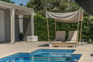 普莱诺斯Dareia Suites的凉亭,泳池旁配有2把躺椅
