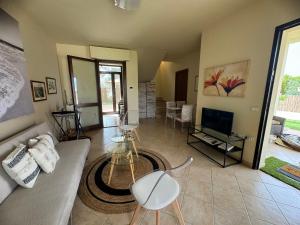 un soggiorno con un divano e una TV di Villa Oliva in Quartu Sant Elena, Capitana, with big Garden and Sea view! a Capitana