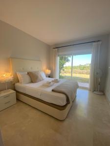a bedroom with a large bed with a large window at Casa lagoon & pool, Alcazaba by Casa del sol HR in Casares