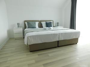 ein Schlafzimmer mit einem großen Bett und einem Holzboden in der Unterkunft Apartman Nativis in Otočac