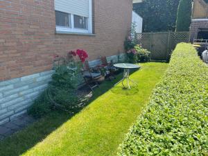 a garden with a table and chairs in the grass at Ankommen und wohlfühlen in Delbrück