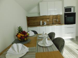 eine Küche mit einem Tisch und einer Obstschale in der Unterkunft Apartman Nativis in Otočac