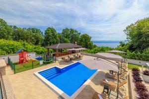 an outdoor pool with a slide and a playground at Apartmani Vesna in Opric