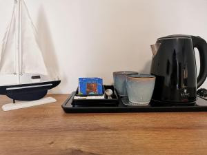 a tray with a coffee maker and cups on a table at Dom gościnny z restauracją - Rejs in Dziwnów