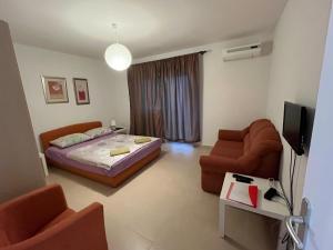 a bedroom with a bed and a couch and a tv at Apartments Mais Tisno in Tisno