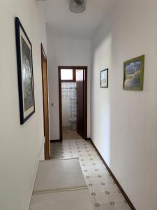 pasillo con paredes blancas y baño con aseo en Casa Marbella, en Sottomarina 6 fotos más