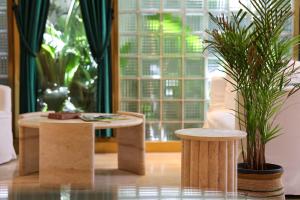 ein Zimmer mit zwei Tischen und einer Topfpflanze in der Unterkunft The Xon Hotel in Cesme