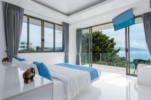 a bedroom with a large bed and a large window at Villa Oceane in Thong Son Beach