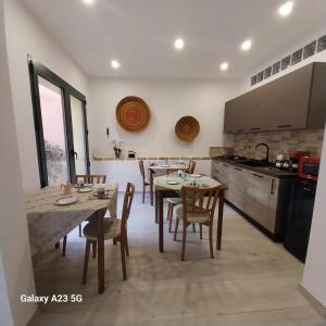 a kitchen with a table and chairs in a room at S'Arrollieddu in Villaputzu +23 photos