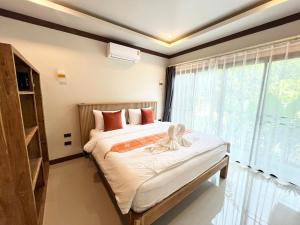 a bedroom with a bed and a large window at Bang Po Hut in Ban Bang Po