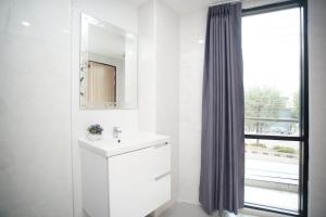 a white bathroom with a sink and a window at Tisa Hotel Udonthani in Udon Thani +33 photos