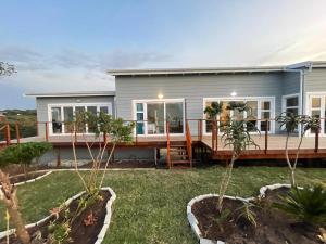 a manufactured home with a deck and a house at Huis Seenekal in Cannon Rocks