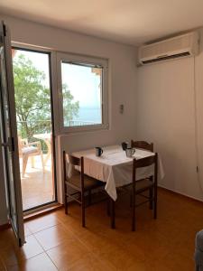 a table and chairs in a room with a window at Villa Lila in Utjeha