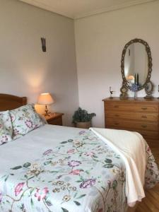 Un dormitorio con una cama y una cómoda con espejo. en Villa Anuska, en Sotomayor