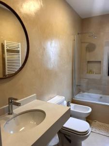 ein Badezimmer mit Waschbecken, Toilette und Spiegel in der Unterkunft Casa en Manzanares in Manzanares