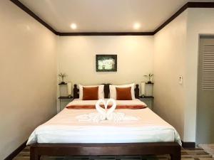 a bedroom with a bed with a white ribbon on it at Bang Po Hut in Ban Bang Po