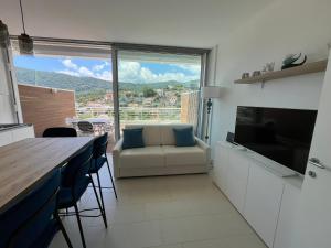 a living room with a couch and a kitchen with a window at A House with a view in Alassio