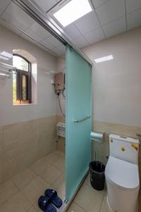 a bathroom with a toilet and a glass shower stall at Kaibu Courtyard Superior Apartment, Changjiang Cable Car Nanbin Road, Chongqing in Chongqing