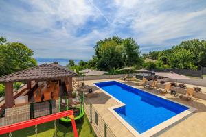 an outdoor swimming pool with a slide and a playground at Apartmani Vesna in Opric