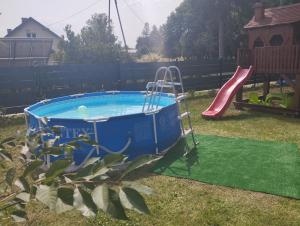 a small pool with a slide and a playground at Kamienna Chata in Urowo