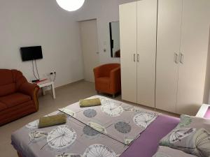 a room with a bed and a couch and a chair at Apartments Mais Tisno in Tisno